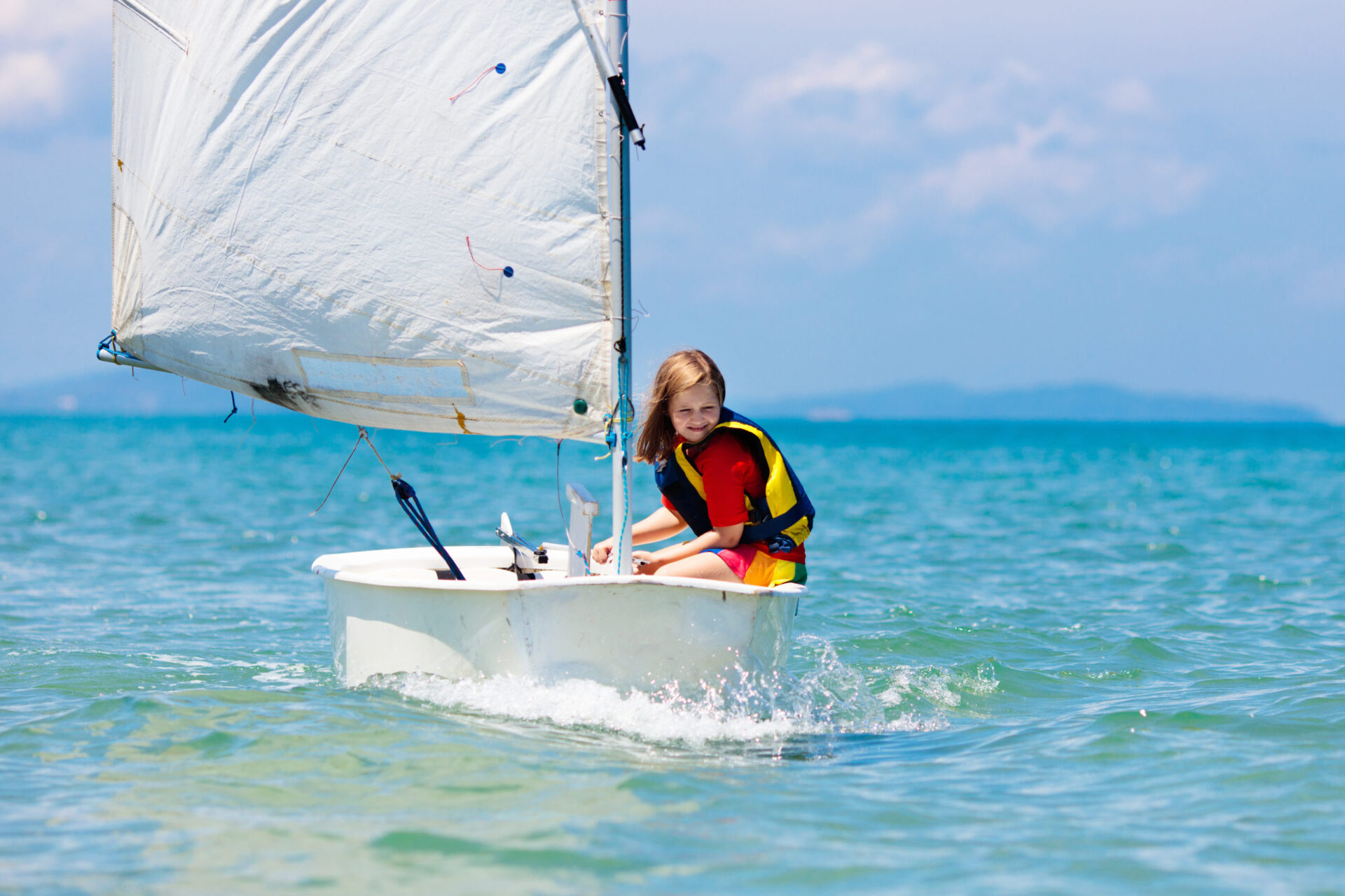 Child sailing. Kid learning to sail on sea yacht. Healthy water sport for school kids. Yachting class for young sailor. Children on boat. Family summer vacation on tropical island. Beach activity.